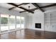 Open living room with a fireplace, custom built-ins, and expansive sliding glass doors to the outdoor patio at 321 Bud Wall Rd, Youngsville, NC 27596