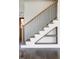 Staircase with wood handrail and black metal balusters features stylishly built-in storage shelves at 321 Bud Wall Rd, Youngsville, NC 27596