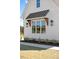 Close-up of a home's window detail, highlighting the wooden awning, brick accents, and exterior lighting fixtures at 321 Bud Wall Rd, Youngsville, NC 27596