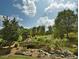 Landscaped walking path with stone bridge and small waterfall at 355 High Woods Rdg, Chapel Hill, NC 27517