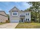 Charming two-story home featuring gray siding, stone accents, and an attached two-car garage at 364 Pecan Valley Way, Four Oaks, NC 27524