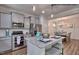 Modern kitchen featuring stainless steel appliances, gray cabinets, granite countertops, and an island with seating at 364 Pecan Valley Way, Four Oaks, NC 27524