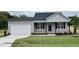 Gray house with a gray roof and a white garage door at 389 Springtooth Dr, Zebulon, NC 27597