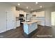 Modern kitchen with white cabinets, granite countertops, and stainless steel appliances at 389 Springtooth Dr, Zebulon, NC 27597