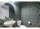 Small powder room with floral wallpaper, gold fixtures, and an oval mirror at 413 Holding Creek Dr, Wake Forest, NC 27587