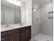 Modern bathroom featuring double vanity sinks, a large mirror, and a glass-enclosed shower at 708 Georgias Landing Pkwy # 14, Raleigh, NC 27603