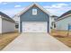 Exterior view of the garage with a white door and blue siding surrounded by grass at 708 Georgias Landing Pkwy # 14, Raleigh, NC 27603