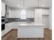 Bright kitchen featuring white cabinets, gray backsplash and a large island with pendant lighting at 708 Georgias Landing Pkwy # 14, Raleigh, NC 27603