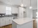 Bright kitchen featuring white cabinets, gray backsplash and a large island with pendant lighting at 708 Georgias Landing Pkwy # 14, Raleigh, NC 27603