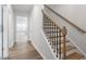 Elegant staircase featuring hardwood steps, black iron spindles, and natural wood banister at 708 Georgias Landing Pkwy # 14, Raleigh, NC 27603