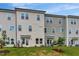 Townhome showcasing light beige siding, lots of windows and a grassy backyard at 7117 Hubner Pl # 22, Cary, NC 27519