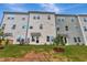 Townhome exterior with light beige siding, multiple windows, and green grassy backyard at 7117 Hubner Pl # 22, Cary, NC 27519