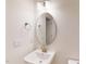 A quaint bathroom with a pedestal sink, oval mirror, and brushed nickel fixtures at 7117 Hubner Pl # 22, Cary, NC 27519