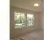 Bedroom with large windows overlooking lush greenery and a neighboring house at 7117 Hubner Pl # 22, Cary, NC 27519
