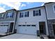 New construction townhouse featuring white siding, a two-car garage and decorative black shutters at 7117 Hubner Pl # 22, Cary, NC 27519