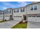 Townhome featuring a two-car garage, dark shutters, and manicured landscaping at 7117 Hubner Pl # 22, Cary, NC 27519