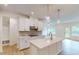 Bright, spacious kitchen with white cabinets, island sink and modern appliances at 7117 Hubner Pl # 22, Cary, NC 27519