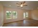 Bright living room with wood floors, a ceiling fan, and a view of the backyard at 7117 Hubner Pl # 22, Cary, NC 27519