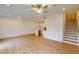 Open-concept living area featuring hardwood floors, ceiling fan, and access to the staircase at 7117 Hubner Pl # 22, Cary, NC 27519