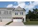 Two-story townhome with gray siding, stone accents, and a two-car garage at 7119 Hubner Pl # 23, Cary, NC 27519