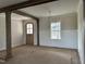 An open living room with decorative wood columns, large window, and natural wood trim at 810 Maggie Way, Wendell, NC 27591