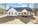 Rear view of the home featuring a wooden porch, a well-manicured yard, and windows overlooking the backyard at 85 Arbor Dr, Youngsville, NC 27596