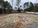 Large lot with trees and construction materials in the back yard at 85 Arbor Dr, Youngsville, NC 27596