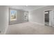 Carpeted bedroom featuring two windows and ensuite bathroom at 85 Arbor Dr, Youngsville, NC 27596