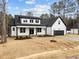 Two-story farmhouse with black and white accents, a spacious two-car garage, and well-kept lawn at 85 Arbor Dr, Youngsville, NC 27596