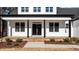 Inviting front porch with black columns and door, brick-lined steps, and well-manicured landscaping at 85 Arbor Dr, Youngsville, NC 27596