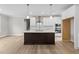 Bright kitchen featuring stainless steel appliances, white cabinetry, a kitchen island, and hardwood floors at 85 Arbor Dr, Youngsville, NC 27596