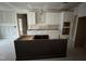 Partially completed kitchen features white cabinets and a dark kitchen island awaiting countertops at 85 Arbor Dr, Youngsville, NC 27596