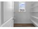 Bright pantry featuring white walls and shelves, and a window to let in natural light at 85 Arbor Dr, Youngsville, NC 27596