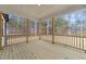 Covered porch with wood flooring, railing and multiple support columns, overlooking a wooded area at 85 Arbor Dr, Youngsville, NC 27596