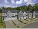 New construction townhomes featuring attached garages and modern exteriors with landscaped yards and a beautiful tree line backdrop at 8945 Kennebec Crossing Drive # 54, Angier, NC 27501