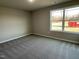 Well-lit bedroom featuring a large window and carpet flooring at 93 Faucette Dr, Selma, NC 27576
