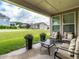 Cozy covered patio with comfortable seating, planters, and a great view of the green backyard at 13 Needham Ln, Clayton, NC 27527