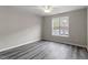 Bedroom with wood-look floors and window with parking view at 1801 Trailwood Heights Ln # 201, Raleigh, NC 27603