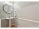 Bathroom with white pedestal sink, round mirror and neutral wall color at 2031 Rivergate Rd # 105, Raleigh, NC 27614