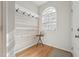 Welcoming entryway with wood-look accent wall, coat hooks, and natural light from arched window at 2031 Rivergate Rd # 105, Raleigh, NC 27614