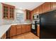 Kitchen featuring wooden cabinets, stainless steel microwave, and black appliances at 2031 Rivergate Rd # 105, Raleigh, NC 27614