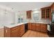 Bright kitchen featuring wooden cabinets, black appliances, white countertops, and hardwood floors at 2031 Rivergate Rd # 105, Raleigh, NC 27614