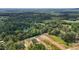 An aerial view showcases beautiful homes near serene ponds and vast, lush forests at 250 Ellington Rd, Graham, NC 27253
