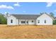 Rear exterior view of a white home with a covered back porch and ample backyard space at 250 Ellington Rd, Graham, NC 27253