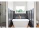 Modern bathroom with a free-standing tub, stone floors, and tiled shower at 250 Ellington Rd, Graham, NC 27253