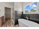 Stylish bathroom with a freestanding tub, elegant fixtures, wainscoting, and a glass-enclosed shower at 250 Ellington Rd, Graham, NC 27253