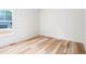 Bedroom showcases wood flooring and a window overlooking the backyard and blue garage at 250 Ellington Rd, Graham, NC 27253