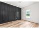 Bedroom with wood floor features a black accent wall and window at 250 Ellington Rd, Graham, NC 27253