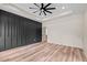 A bedroom featuring a modern ceiling fan, wood-look floors and a gray accent wall at 250 Ellington Rd, Graham, NC 27253