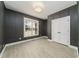 A bedroom featuring dark gray wood paneling, a neutral ceiling fixture, and a large window at 250 Ellington Rd, Graham, NC 27253